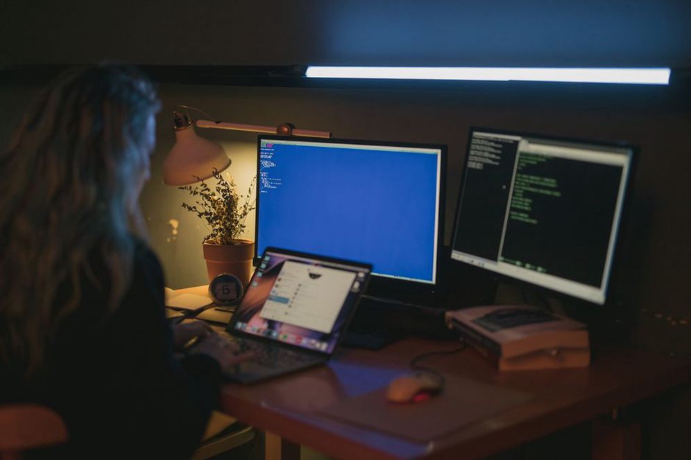 Multi-monitor setup displaying code across screens