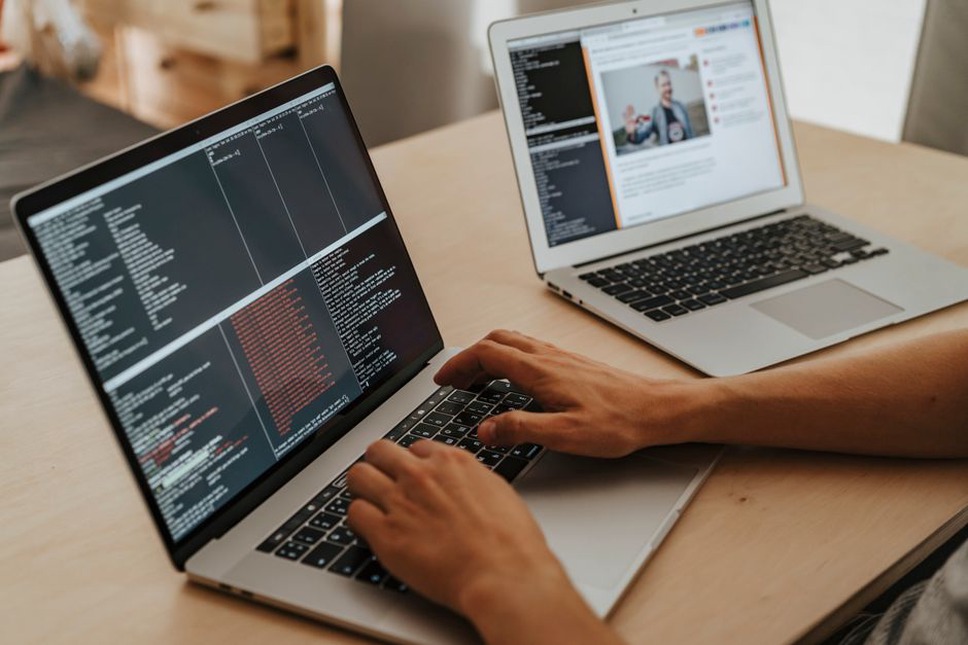 developer working on robot firmware at a desk with a prototype