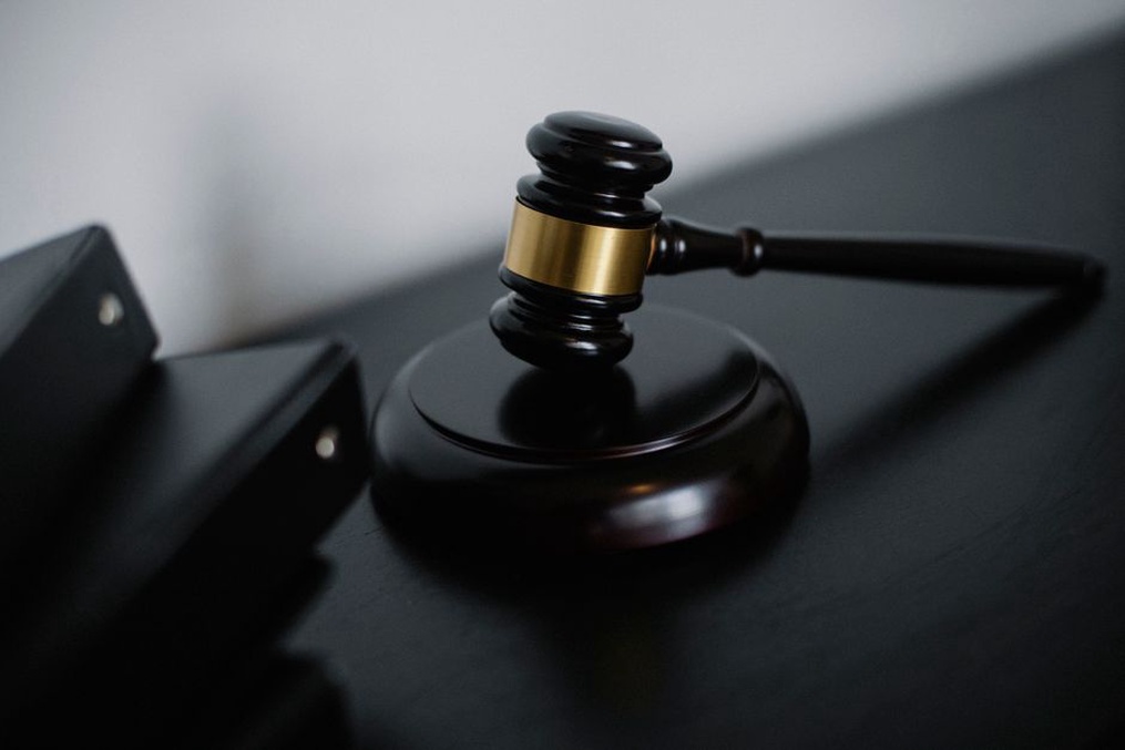 Gavel beside a laptop showing a disclaimer text on screen