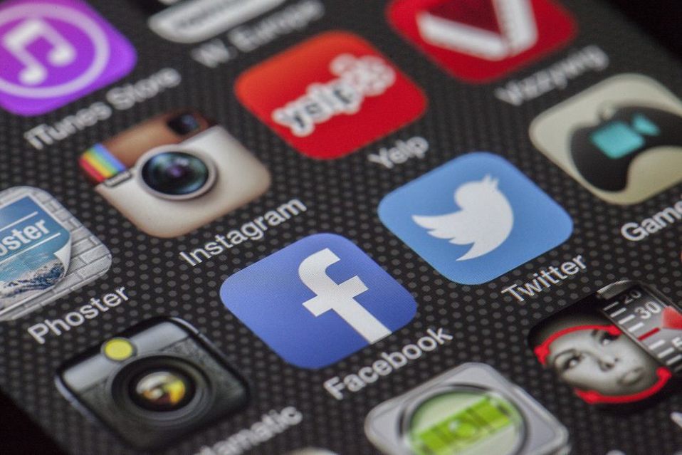 Smartphone displaying separate Instagram, WhatsApp, and Facebook icons