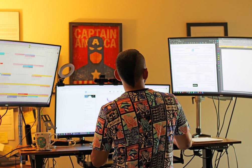 Person arranging multiple screens and a laptop for cybersecurity practice